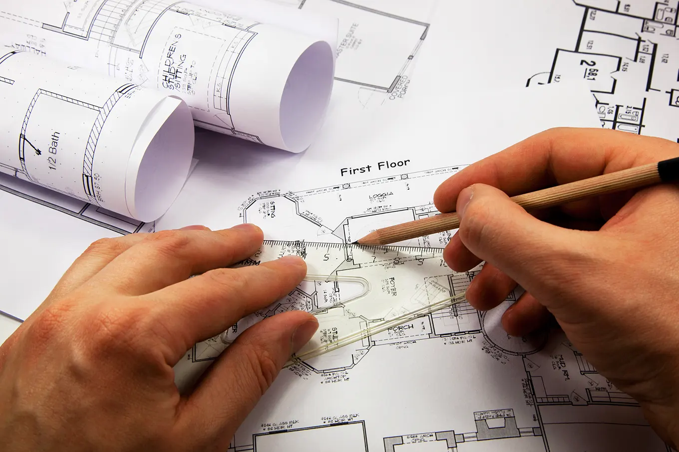 Hand drawing a floor plan over architectural drawings