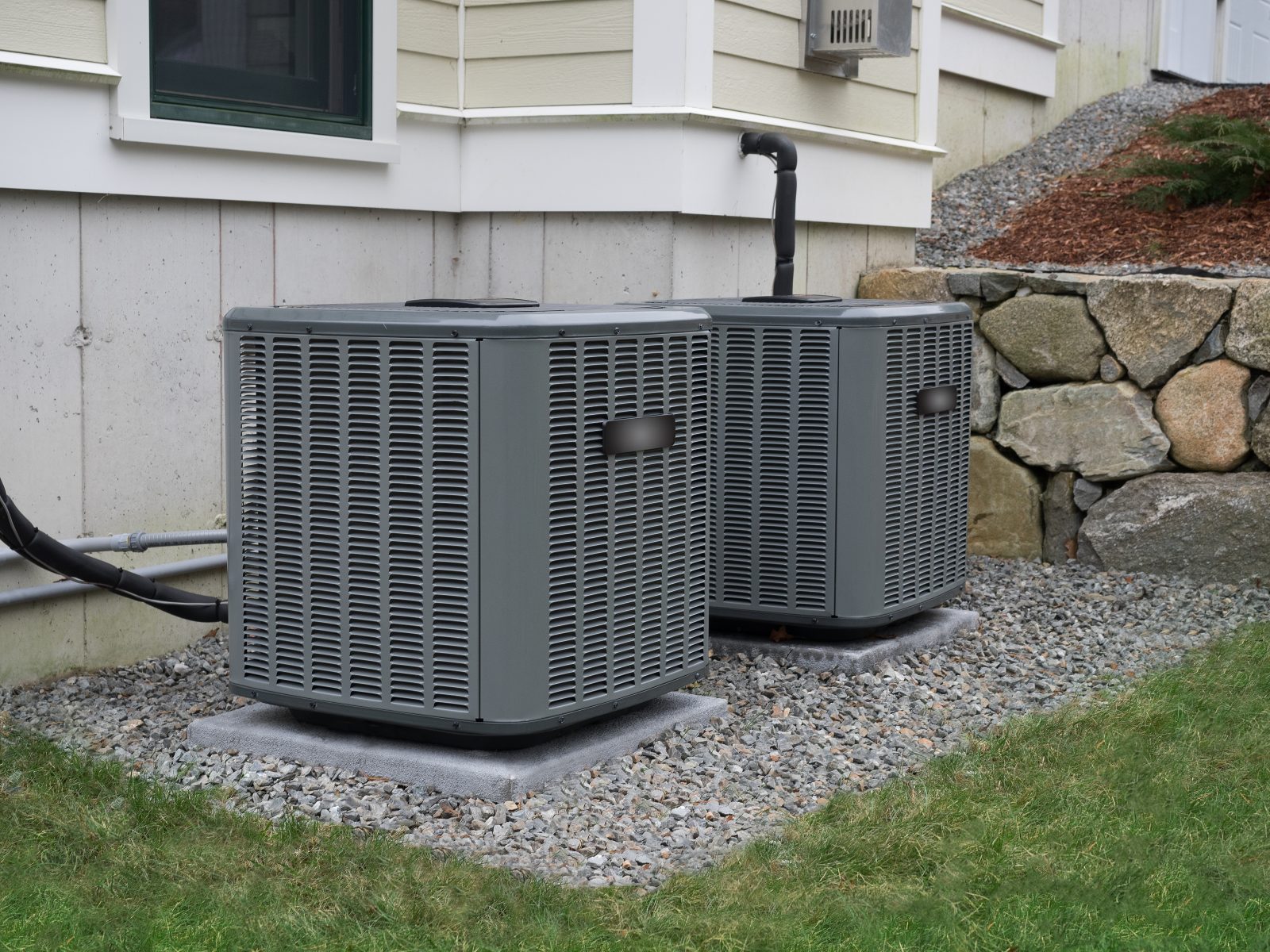 Two air conditioning condenser units beside a house