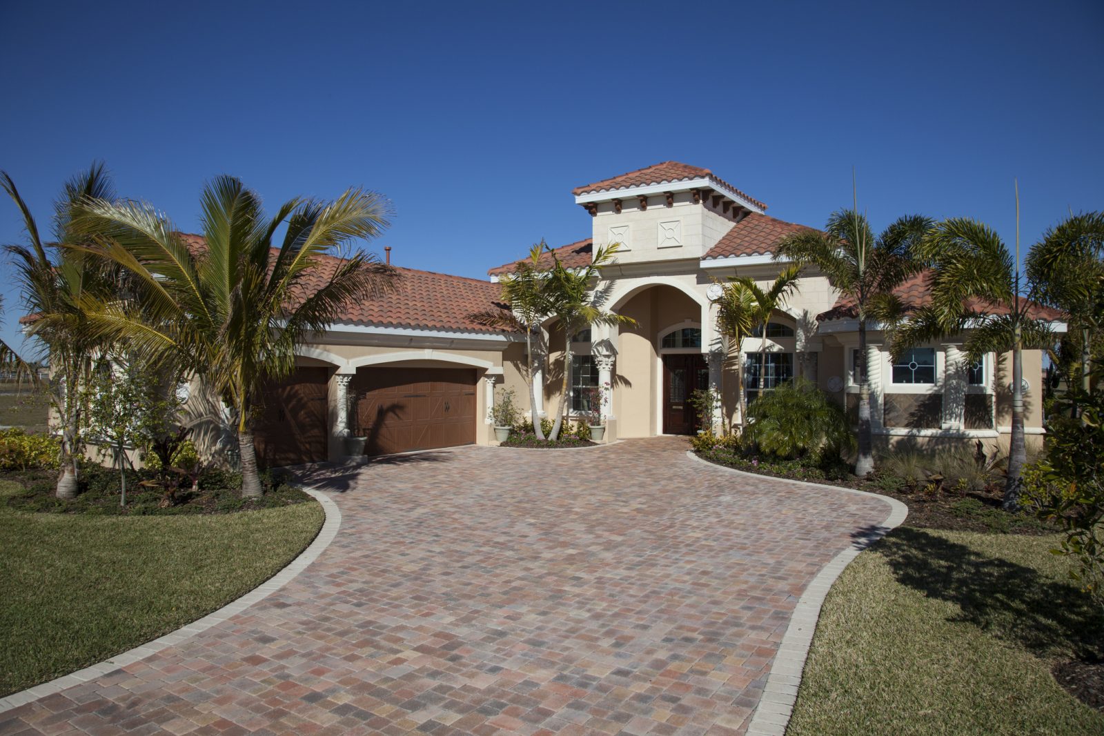 Wide paver driveway leading to a two-car garage at a Florida house