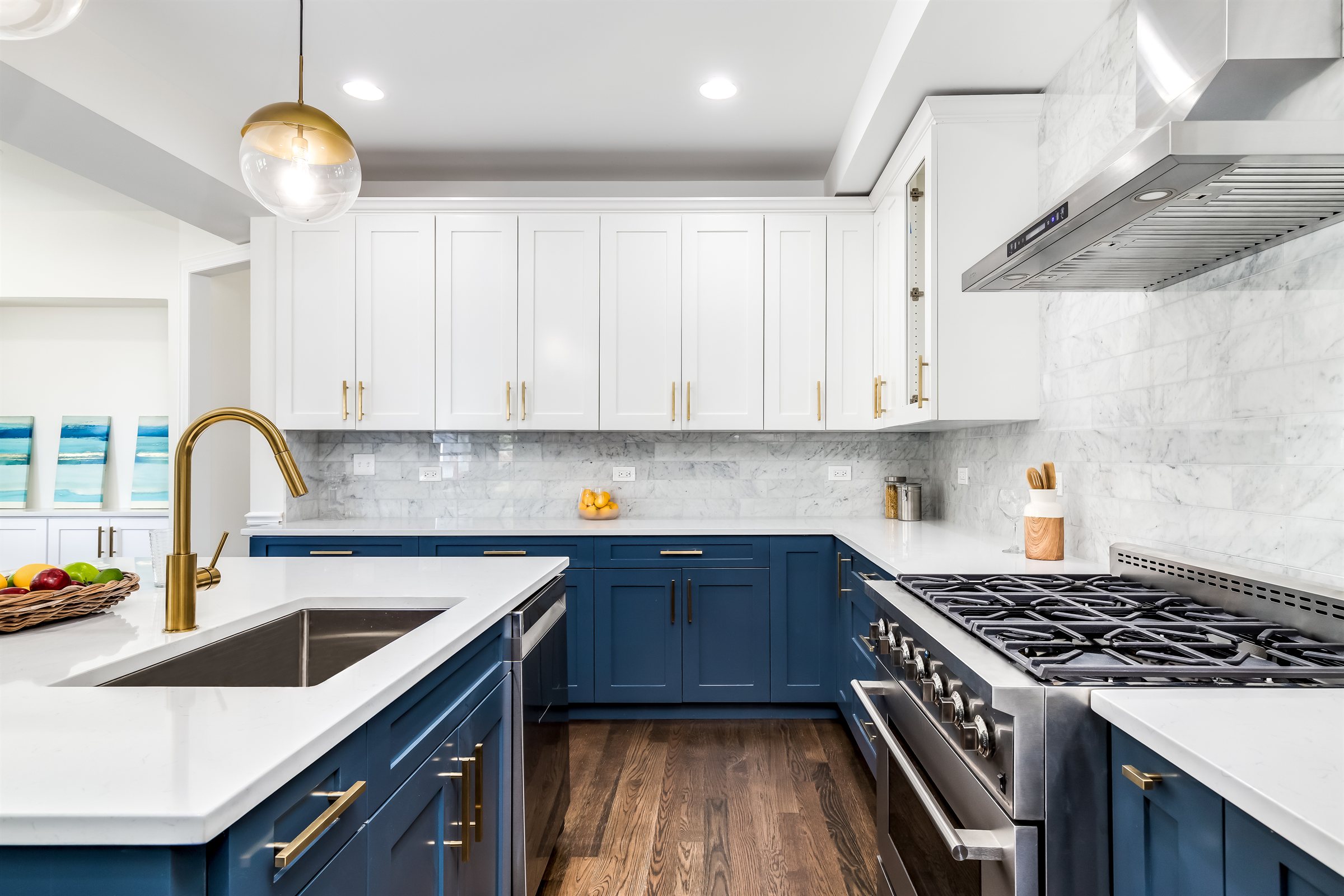 Navy and white kitchen remodel with a marble backsplash and professional range